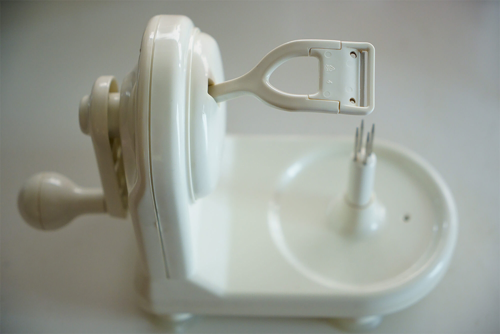 活用している皮剥き器のひとつで、アップルピーラー/パール金属社製。 本体24×12×17㎝。吸盤付き。 突起にリンゴを刺し、左手でハンドルを回す。