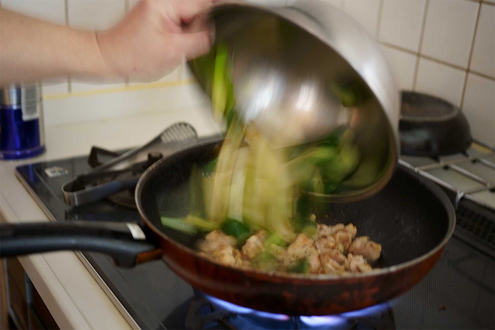 (E) 焼き目を付けた鶏肉にキュウリと長ネギを加える。まとめて加熱すると水分が出て焦げ目が付かない。