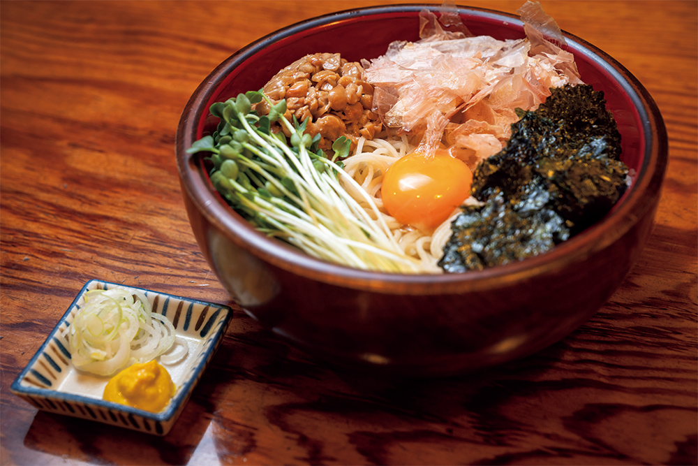 看板メニューの「納豆そば」(¥1,050/税込)は、3代目主人の息子が小学生の時に生まれたメニュー。冷たいそばだが、季節を問わず人気。