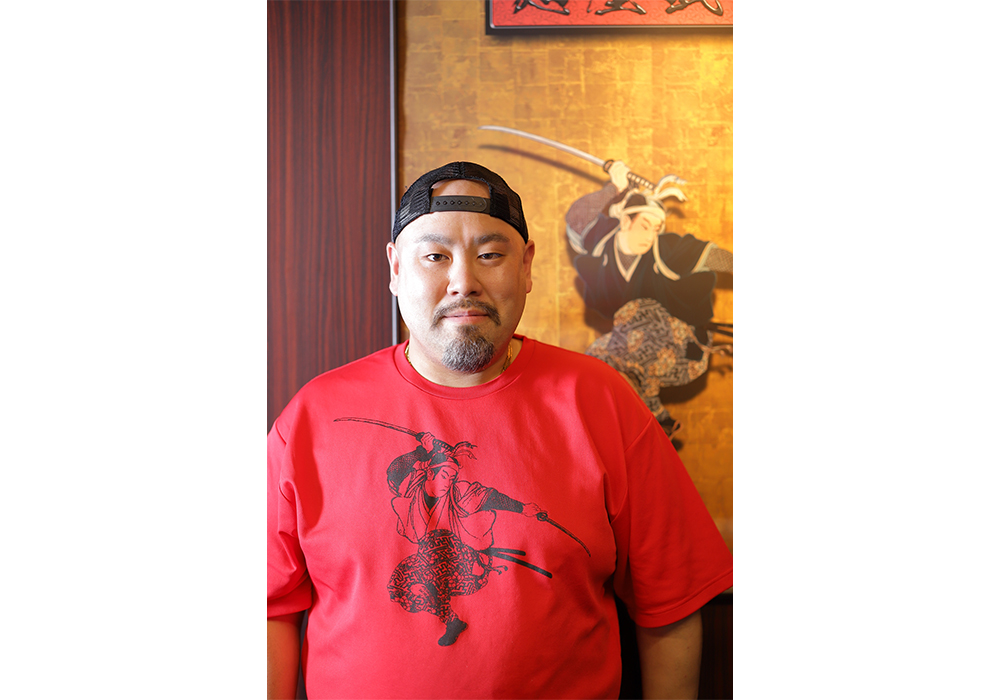杉山浩二さん。様々なラーメン店の調理を経て、8年前から麺屋武蔵のレシピ開発を担当する。ラーメン作り18 年。日本薬科大学と共同で開発した薬膳ラーメンや、宮城県復興支援のために同県産のほやを活用をした調味料「ほや醤」を開発するなど、コラボレーションで斬新なメニュー開発を続ける。『抽象と捨象のラーメン調理法』(麺屋武蔵著/旭屋出版)。