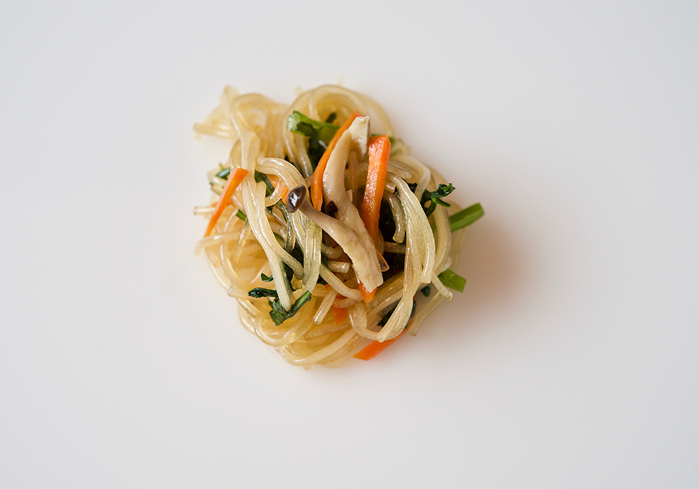 春雨と人参、春菊、茸の炒め物。菜種油でニンニクを熱し、せん切りニンジンと旬の青菜、シメジ、戻した春雨、塩を加えて炒める。