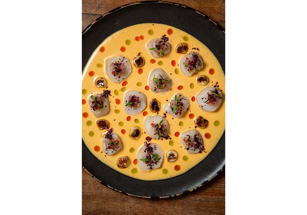 (写真2枚目)「Tiradito de Conchas Thai」(45ソレス)。ホタテのティラディートにタイ風レチェ・デ・ティグレと日本のシソをプラスしたアジアン・ペルビアンらしい一品。
