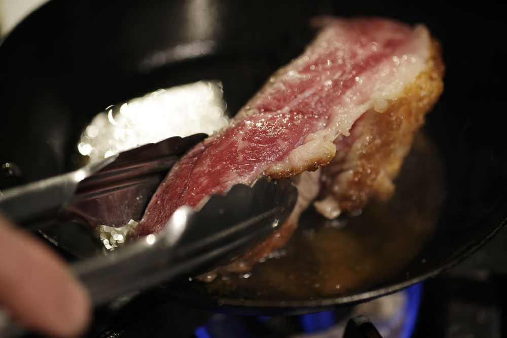 無角和種のトモサンカク(モモの一部)を塊で調理する。フライパンで表面を焼き付けてから、肉にストレスをかけないよう、サラマンダーでゆっくり火を入れていく。