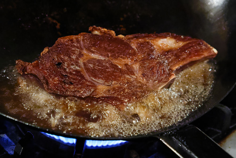 Lボーンのオーブン焼き。まずフライパンで表面を焼き固め、肉汁を閉じ込めてから、オーブンに入れる。