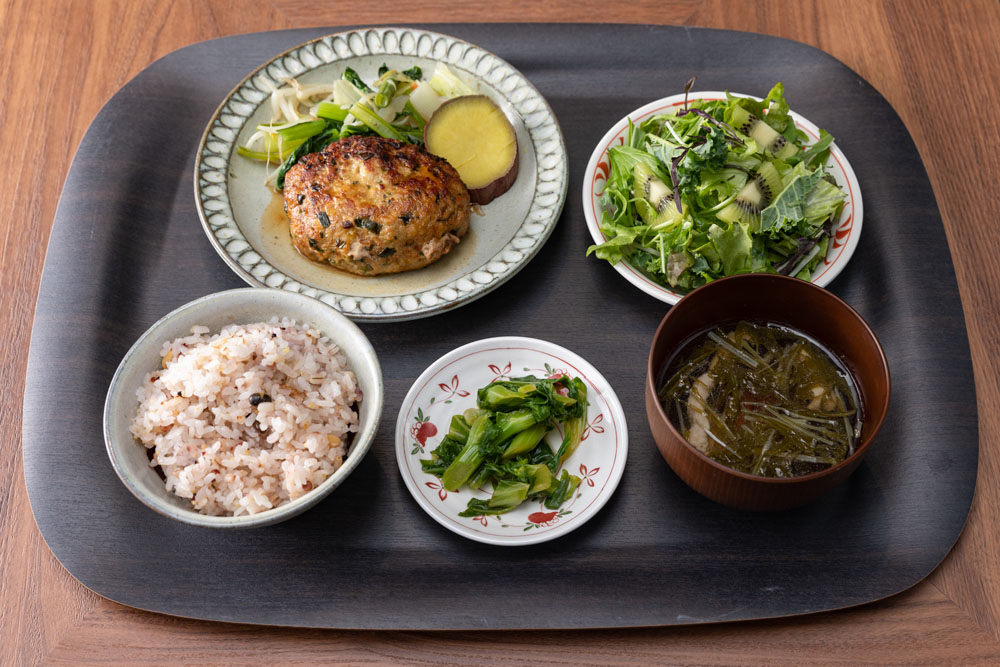 3月24日のL定食「群馬県産せせらぎポークのハンバーグ」。肉がみっしり詰まって、満足度が高い。