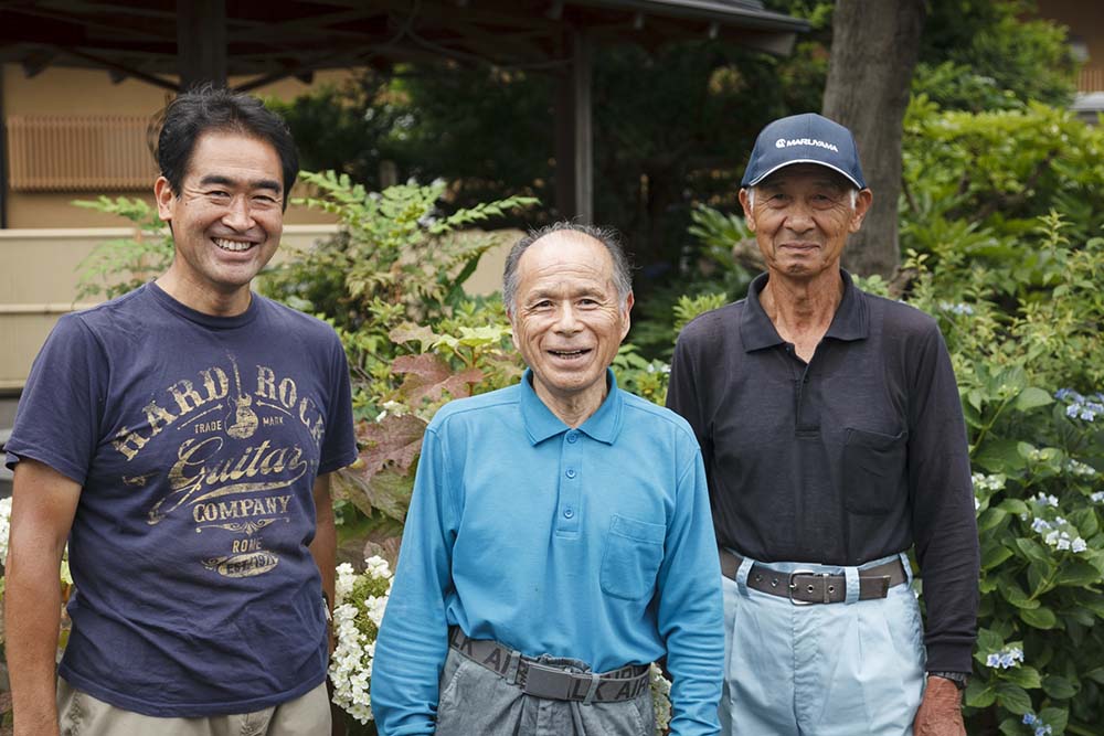 中央が田中久幸さん。一緒に採蜜を手伝う中村農園の中村安幸さん(右)と販売を担当する中村克之さん(左)。