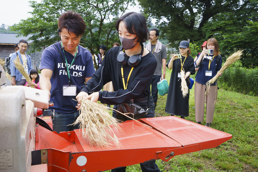 参加者一人ひとりが小麦の束を掴んで、脱穀機へ。