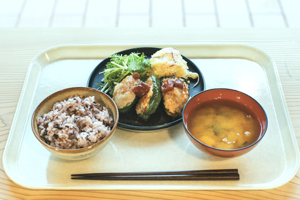 昼の定食:神山で採れたピーマンの肉詰め、黒米ごはん、味噌汁。フードハブ・プロジェクトで4年間農業研修をした後に新規就農した松本直也さん・絵美さん夫妻の農園「oronono」のピーマンが主役。