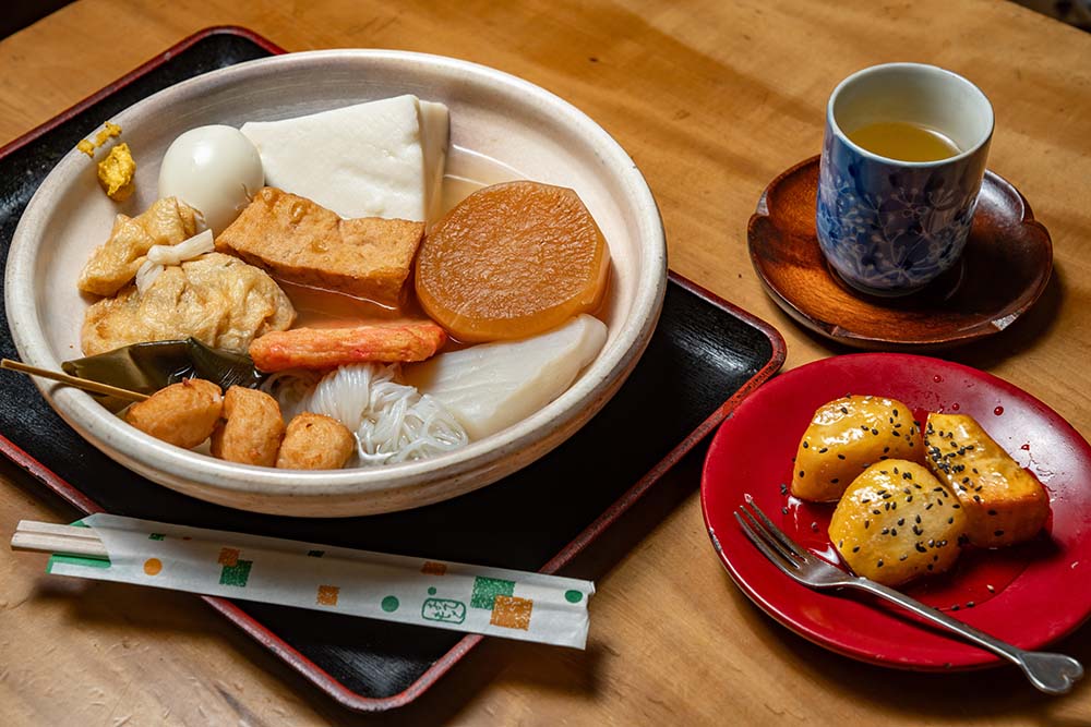 おでんのだしは、煮干しと昆布。ほんのり甘く、澄んだ味わいで、「うちは酒のアテとしてじゃなく、夕食やおやつに食べるおでんだから」と醤油は仕上げに1、2滴加える程度。「あとは練り物の味がだしに染みてくる」。8時間煮詰めた蜜を絡める大学芋は、ビジネス用のお土産としても人気。