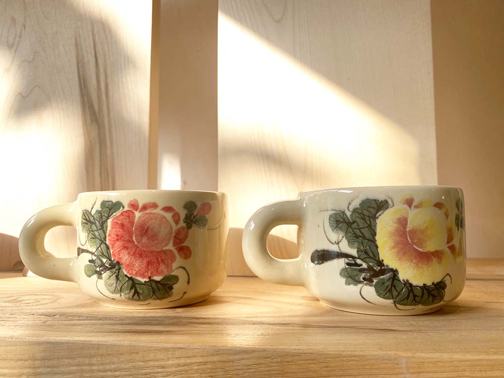 (写真)伝統的な芍薬の花を描いたマグカップ。赤色、黄色、ピンク色、青色など色使いも多様。絵柄は一つひとつ手描きのため、それぞれ異なる味わいをもつ。各149000ベトナムドン。