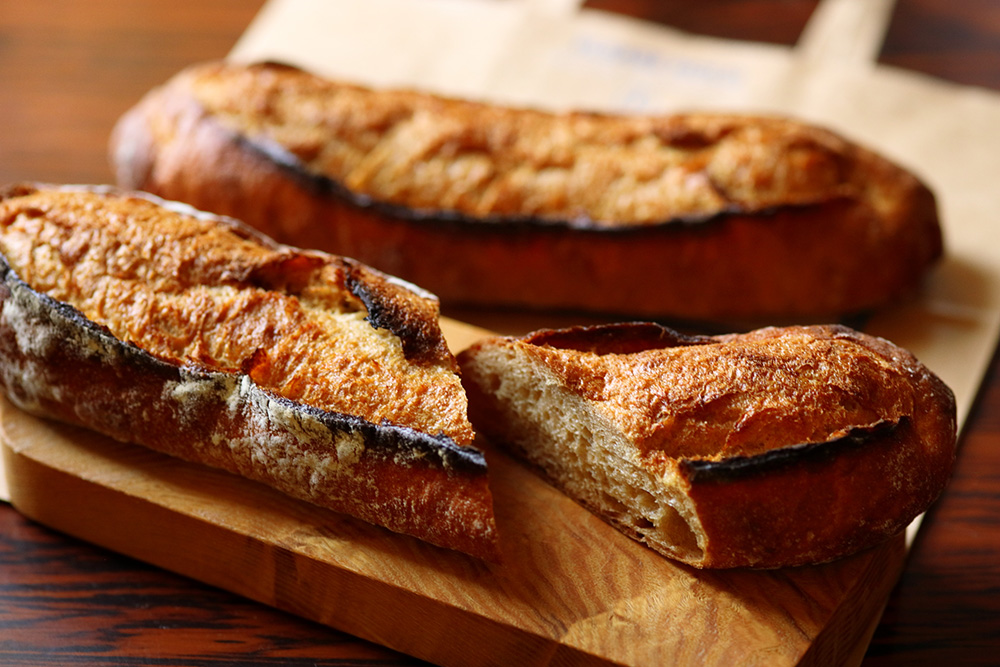 「SHŌPAIN ARTISAN BAKEHOUSE」の「61 SIXTY-ONE」を使ったバゲット。「61は膨らむ力が弱いので、強い粉を配合する必要がある」と平山さん。「61 SIXTY-ONE」30%、ゆめかおり70%の配合。「少し豆っぽい独特の風味で他の粉にはない個性がある。味が淡白なゆめかおりと合わせることで、61の風味を生かしている」。