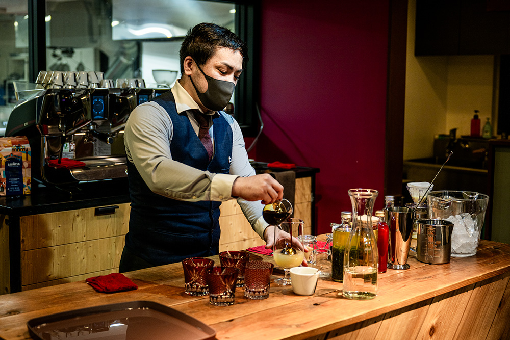 サーブする鈴木さんの様子